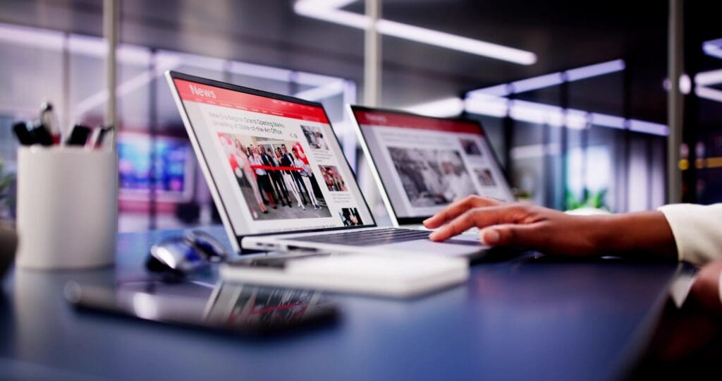 American,woman,views,online,news,articles,on,laptop,and,phone