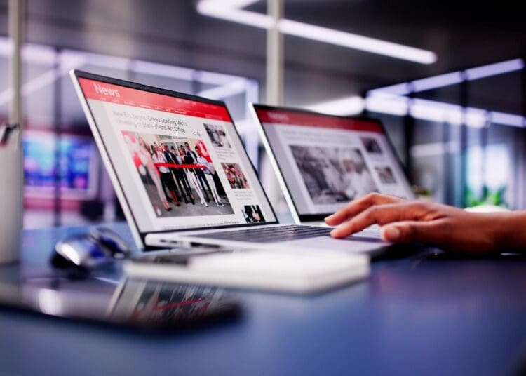 American,woman,views,online,news,articles,on,laptop,and,phone